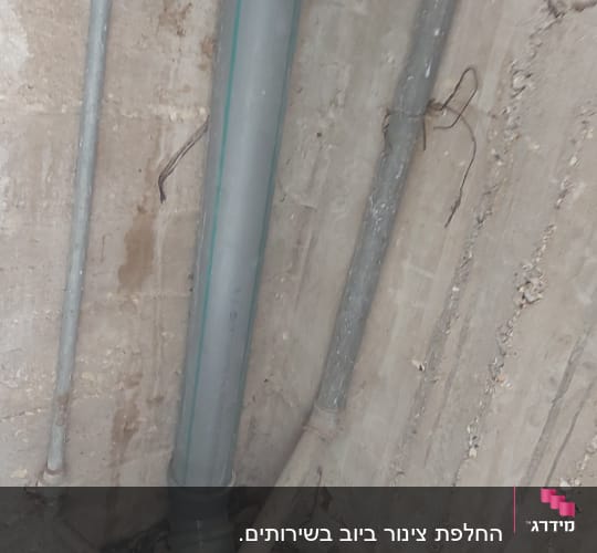 צינורות פלסטיק וברזל על קיר בטון